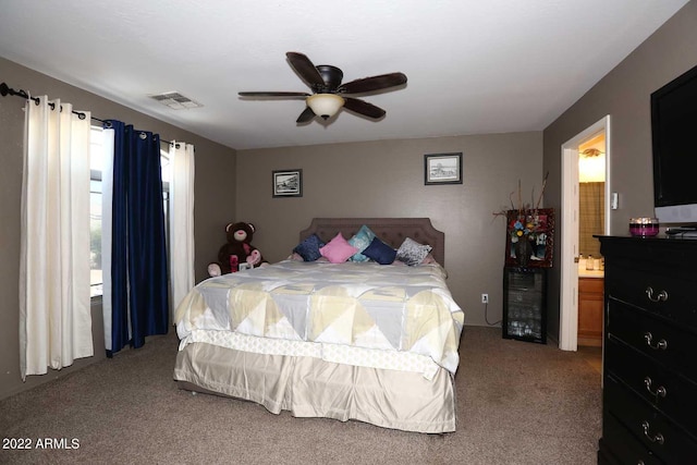 carpeted bedroom featuring ceiling fan and ensuite bath