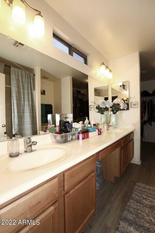 bathroom with dual vanity and wood-type flooring