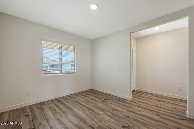 spare room with recessed lighting, wood finished floors, and baseboards