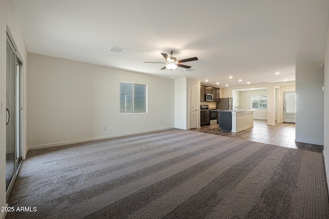 unfurnished living room featuring recessed lighting, visible vents, ceiling fan, and baseboards