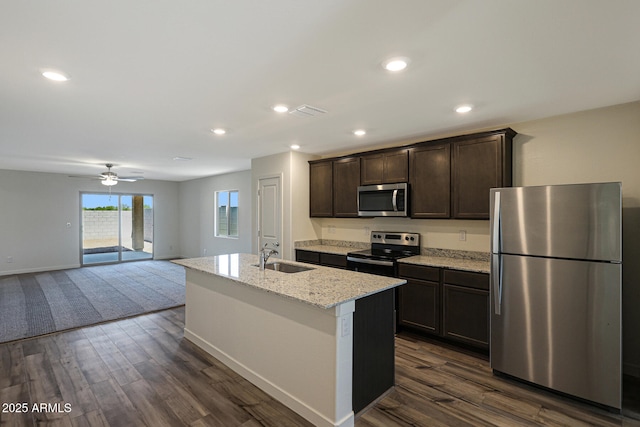 kitchen with an island with sink, dark wood-style floors, open floor plan, stainless steel appliances, and a sink