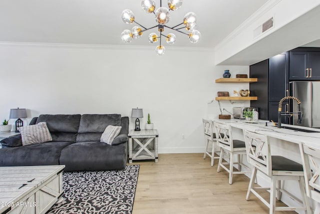 living room featuring light hardwood / wood-style flooring, crown molding, and a notable chandelier