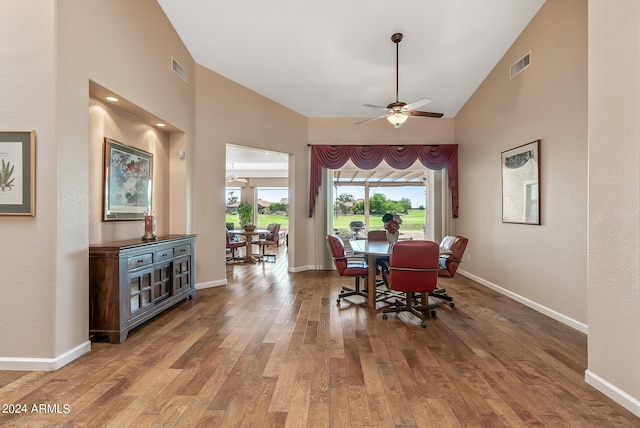 dining area featuring wood-type flooring, ceiling fan, and high vaulted ceiling