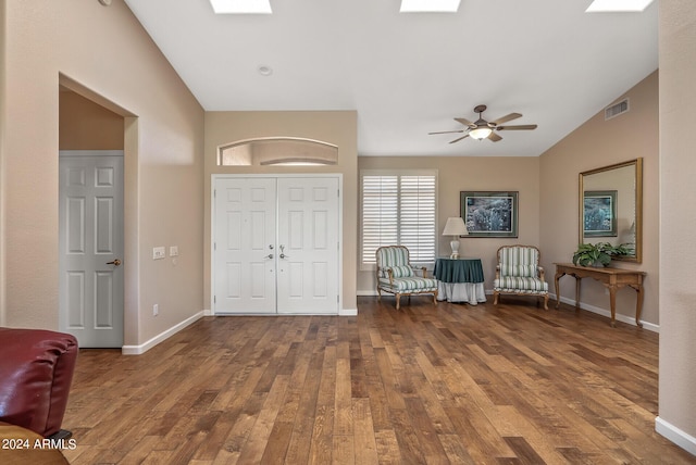 unfurnished room with lofted ceiling with skylight, hardwood / wood-style floors, and ceiling fan