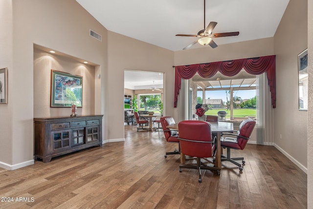 dining room with hardwood / wood-style flooring, ceiling fan, and high vaulted ceiling