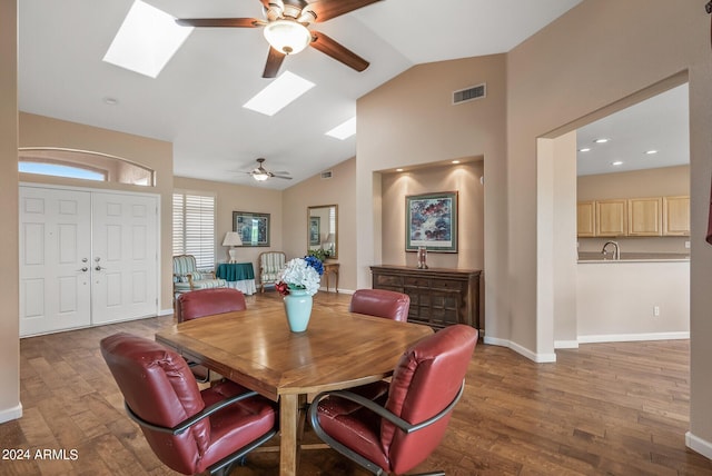 dining room with dark wood-type flooring, ceiling fan, and lofted ceiling with skylight