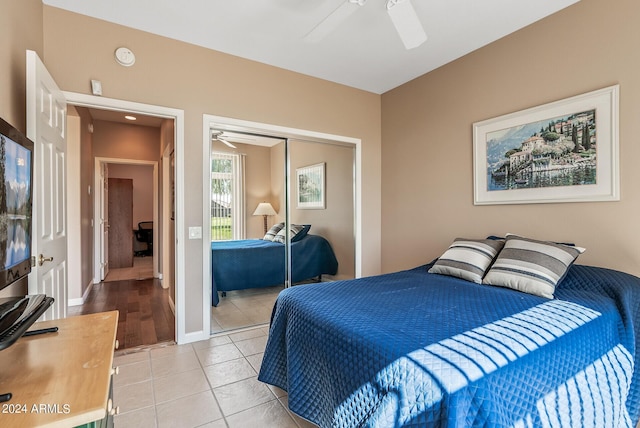 bedroom featuring light tile patterned floors, ceiling fan, and a closet