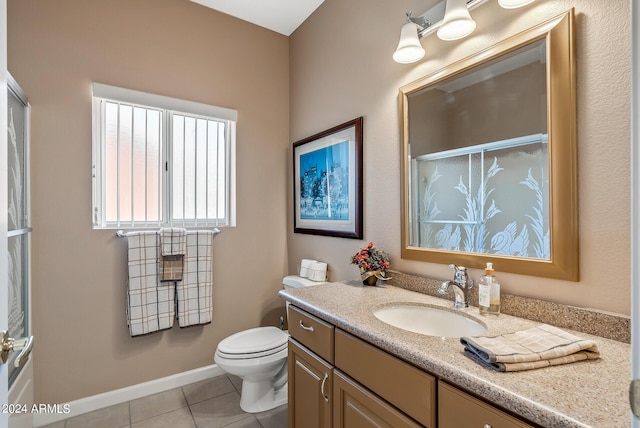 bathroom featuring tile patterned floors, vanity, toilet, and an enclosed shower