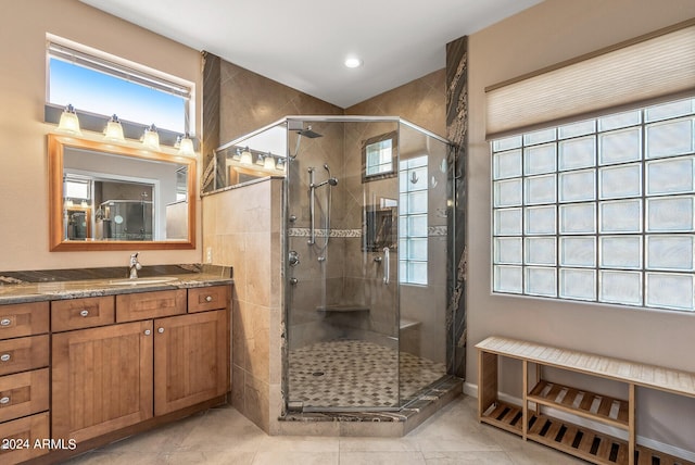 bathroom featuring a shower with door and vanity