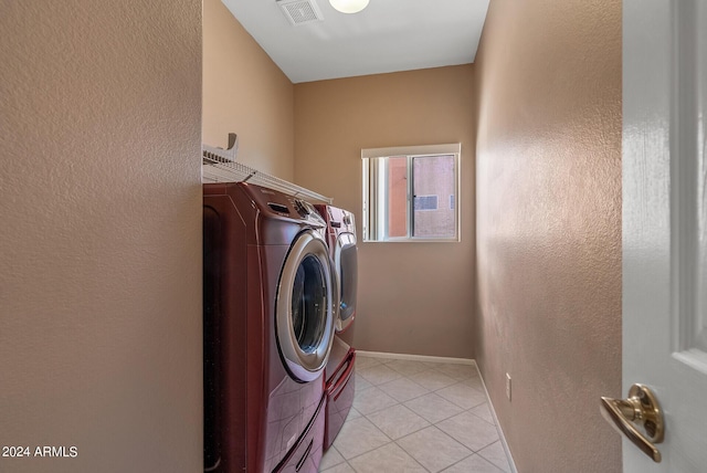 laundry area featuring light tile patterned flooring and washing machine and dryer