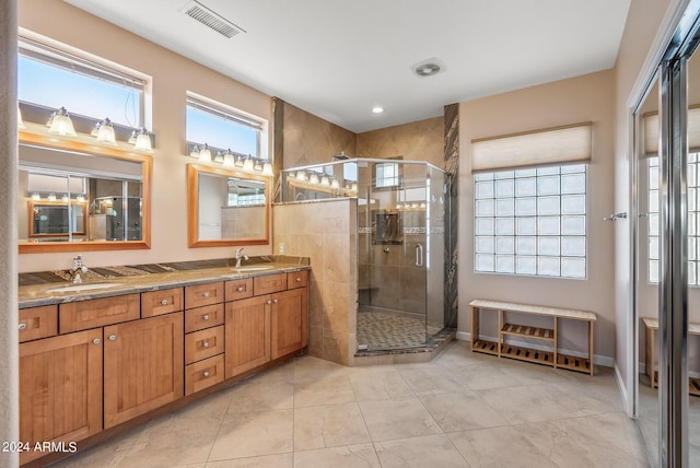 bathroom featuring a shower with door and vanity