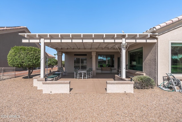 back of property with a pergola and a patio area