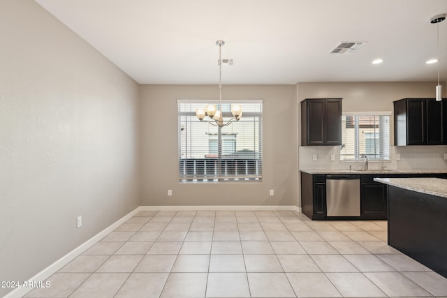 kitchen with light stone countertops, backsplash, pendant lighting, an inviting chandelier, and dishwasher