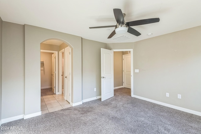 unfurnished bedroom with ensuite bath, ceiling fan, and light colored carpet