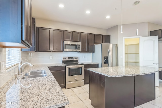 kitchen featuring sink, a center island, pendant lighting, and appliances with stainless steel finishes