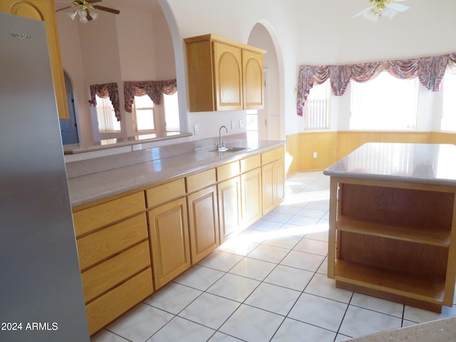 kitchen featuring ceiling fan, light brown cabinetry, light tile patterned floors, and sink