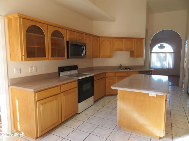 kitchen featuring sink, light tile patterned floors, a breakfast bar, a kitchen island, and appliances with stainless steel finishes