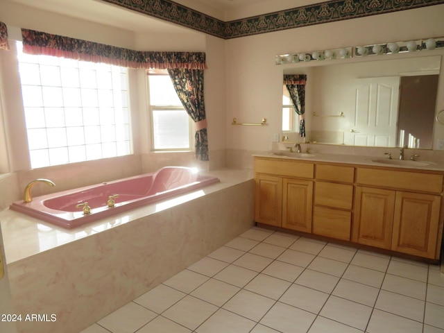 bathroom with tile patterned flooring, vanity, tiled bath, and plenty of natural light