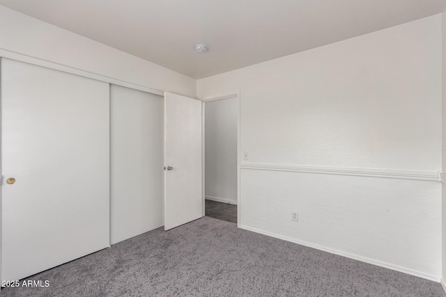 unfurnished bedroom with carpet flooring and a closet