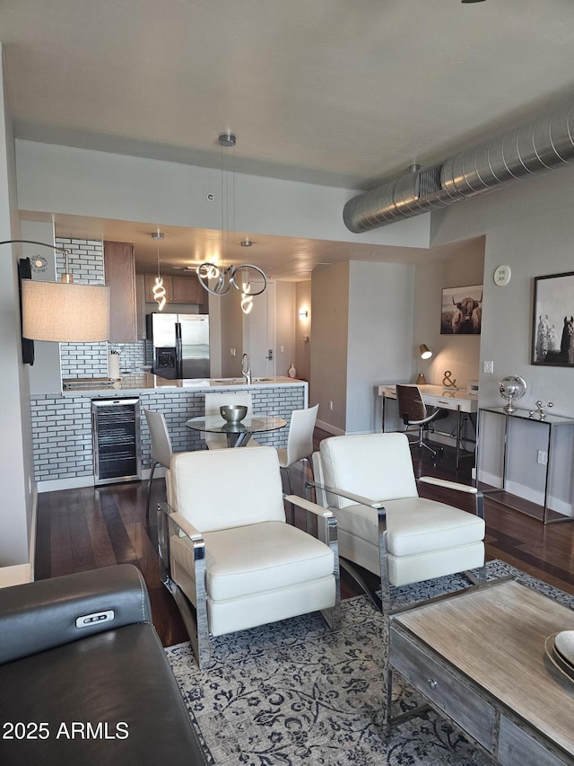 living room featuring hardwood / wood-style flooring, sink, and beverage cooler