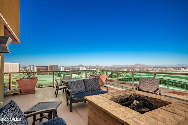 view of patio featuring a mountain view and an outdoor living space with a fire pit