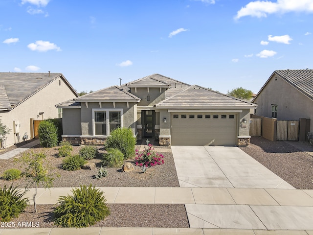 18865 W Mescal St, Surprise, AZ 85388 - view of front of home featuring stone siding, an attached garage, driveway, stucco siding, and a tiled roof