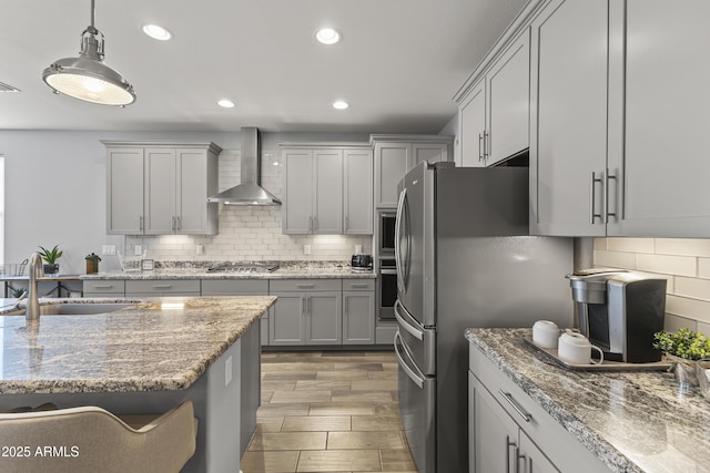 18865 W Mescal St, Surprise, AZ 85388 - kitchen featuring wall chimney range hood, stainless steel appliances, backsplash, recessed lighting, and hanging light fixtures