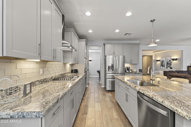 18865 W Mescal St, Surprise, AZ 85388 - kitchen featuring stainless steel appliances, gray cabinetry, light wood-style floors, recessed lighting, and light stone counters
