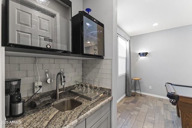 18865 W Mescal St, Surprise, AZ 85388 - kitchen featuring decorative backsplash, dark stone countertops, light wood-style floors, and recessed lighting