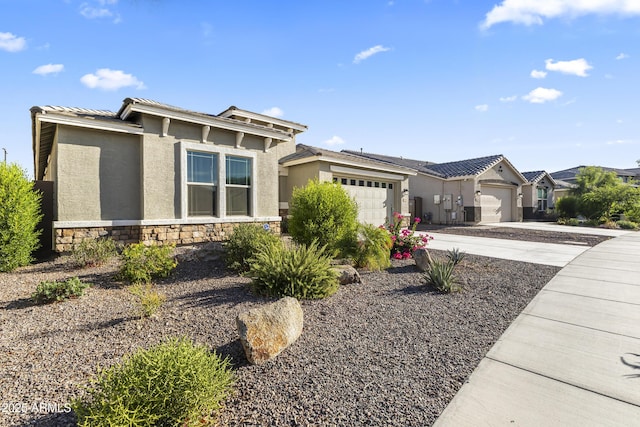 18865 W Mescal St, Surprise, AZ 85388 - view of front of property featuring an attached garage, driveway, stone siding, and stucco siding