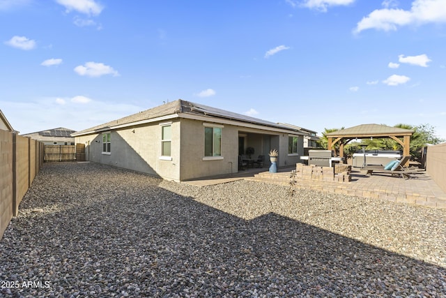18865 W Mescal St, Surprise, AZ 85388 - rear view of property with a hot tub, a patio, roof mounted solar panels, a fenced backyard, and stucco siding