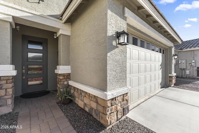 18865 W Mescal St, Surprise, AZ 85388 - doorway to property featuring stucco siding, a garage, driveway, and stone siding
