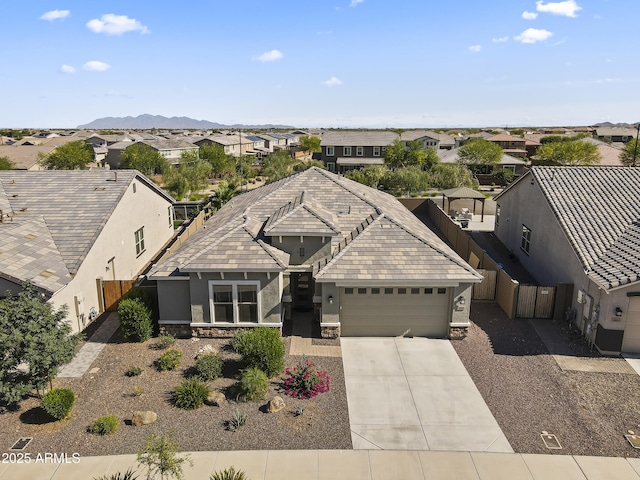 18865 W Mescal St, Surprise, AZ 85388 - view of front facade with a residential view, an attached garage, stucco siding, stone siding, and driveway
