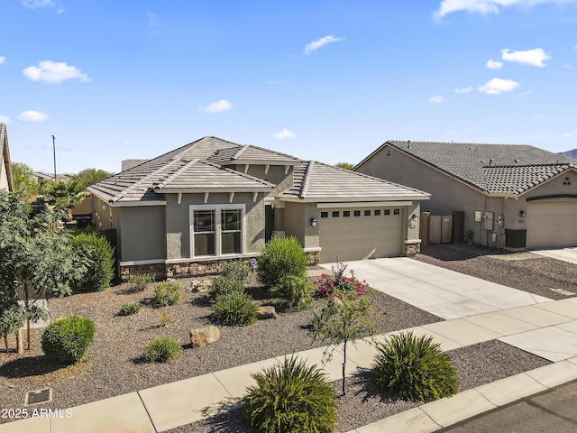 18865 W Mescal St, Surprise, AZ 85388 - view of front facade featuring stone siding, stucco siding, a garage, and driveway
