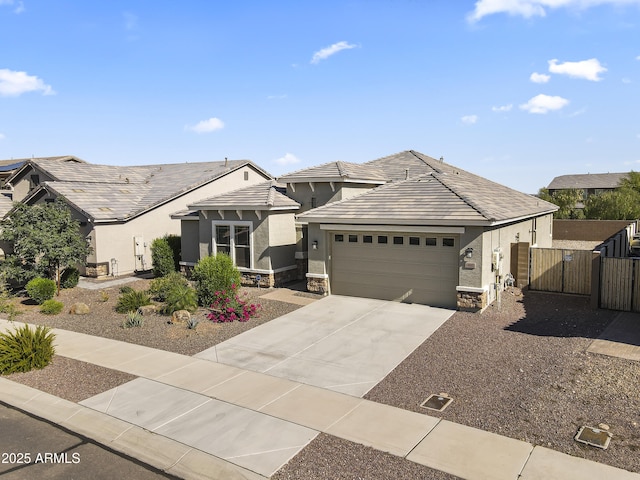 18865 W Mescal St, Surprise, AZ 85388 - view of front of property with a gate, a garage, concrete driveway, stucco siding, and stone siding