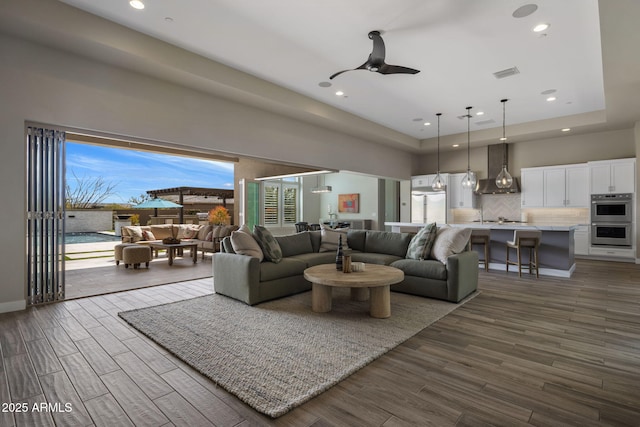 living room featuring visible vents, recessed lighting, dark wood-type flooring, and ceiling fan