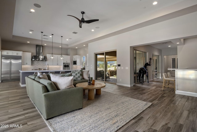 living room featuring recessed lighting, baseboards, and wood finished floors