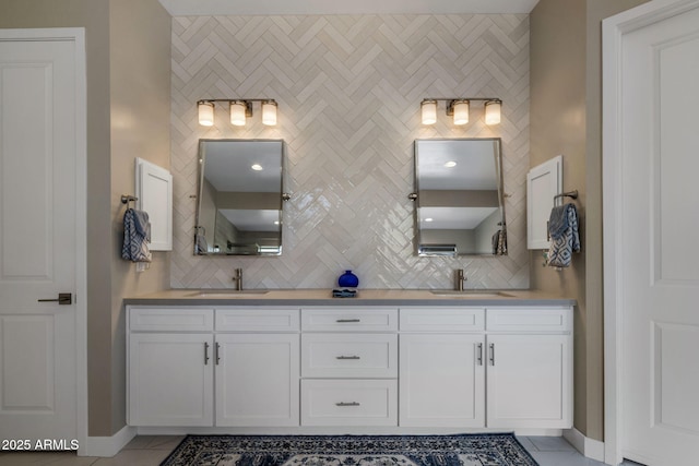 bathroom featuring tile patterned flooring, double vanity, backsplash, and a sink