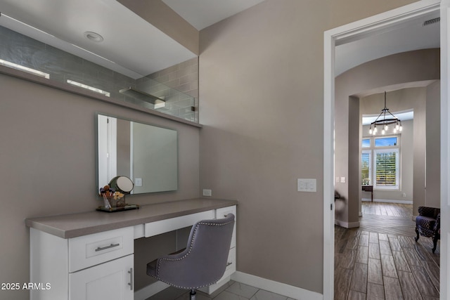 home office with visible vents, built in study area, baseboards, and wood finished floors