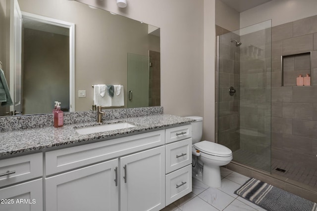 full bathroom featuring a tile shower, toilet, and vanity