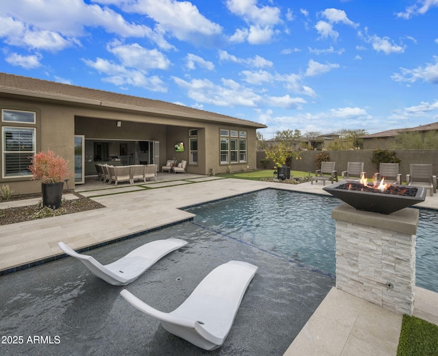 view of swimming pool featuring a fenced in pool, a patio, an outdoor living space with a fire pit, and fence