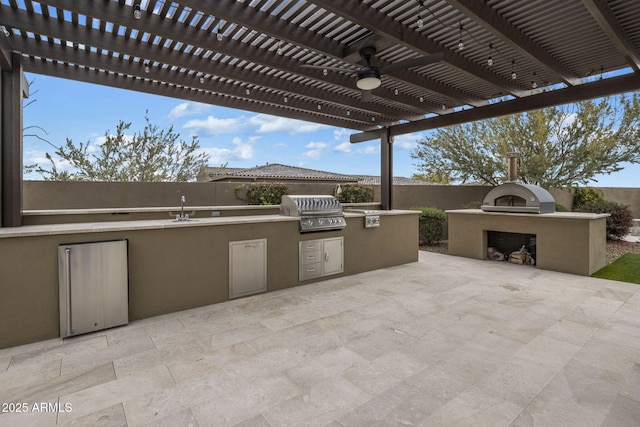 view of patio / terrace with area for grilling, a pergola, a sink, an outdoor fireplace, and exterior kitchen