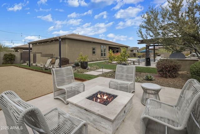 view of patio / terrace featuring an outdoor fire pit and fence