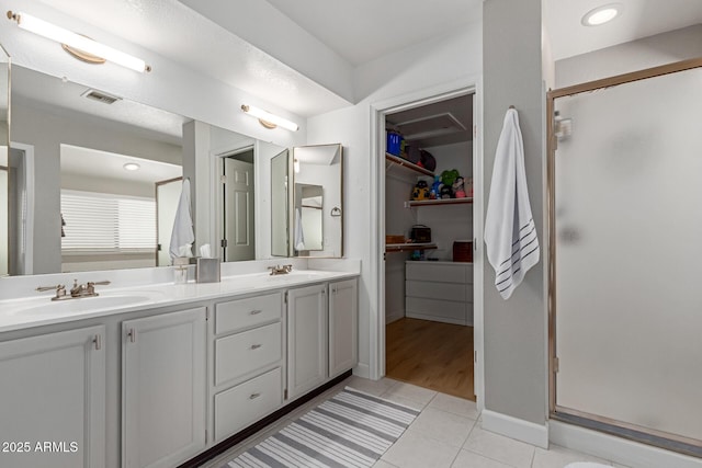 6017 E Kathleen Rd, Scottsdale, AZ 85254 - full bathroom featuring a shower stall, double vanity, tile patterned flooring, and a walk in closet
