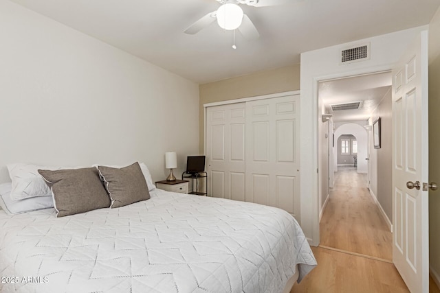 6017 E Kathleen Rd, Scottsdale, AZ 85254 - bedroom featuring arched walkways, light wood-style floors, a closet, and ceiling fan