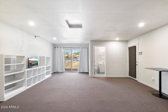 unfurnished living room featuring carpet floors and a textured ceiling