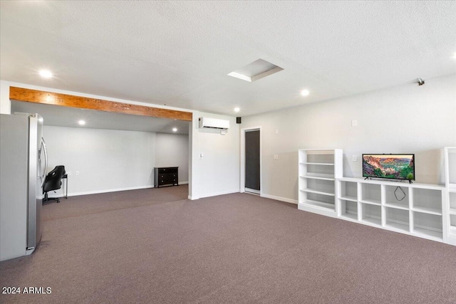 basement with stainless steel fridge, dark carpet, an AC wall unit, and a textured ceiling