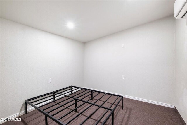 unfurnished bedroom featuring carpet floors and a wall unit AC