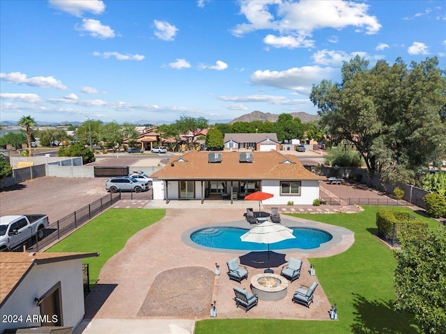 view of swimming pool featuring a yard, a fire pit, and a patio area