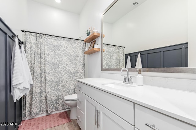 4077 S Quinn Ave, Gilbert, AZ 85297 - full bath with visible vents, vanity, wainscoting, wood finished floors, and toilet